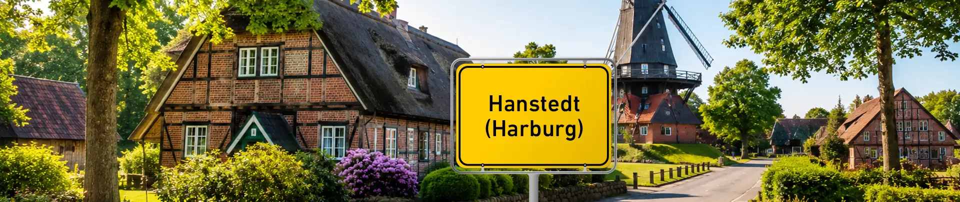 Ortsschild Hanstedt vor Fachwerkhäusern und Kirche